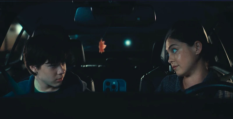 Rosa Salazar and Shylo Molina looking toward one another inside a car.