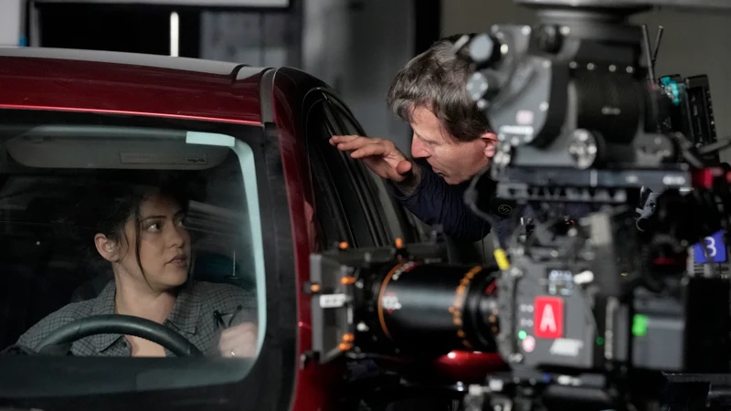 Rosa Salazar in a red pickup with a camera rig alongside.